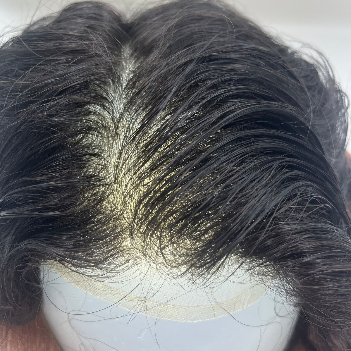 Crown part area showing fine lace base visible between parted dark hair on mannequin head