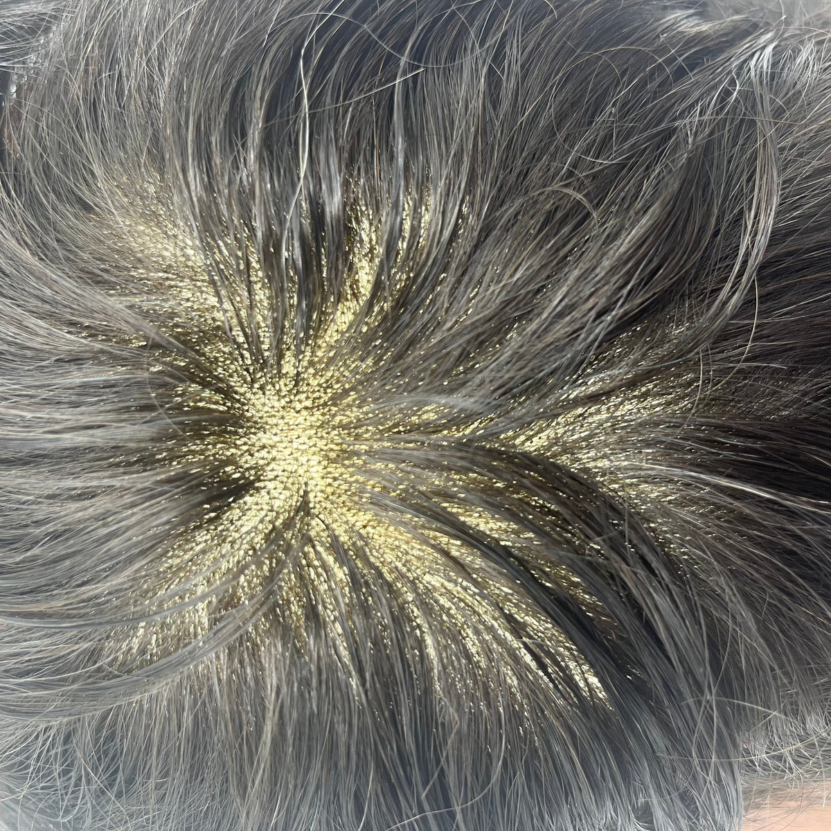 Extreme close-up of natural whorl showing individual strands on fine lace with golden scalp tone