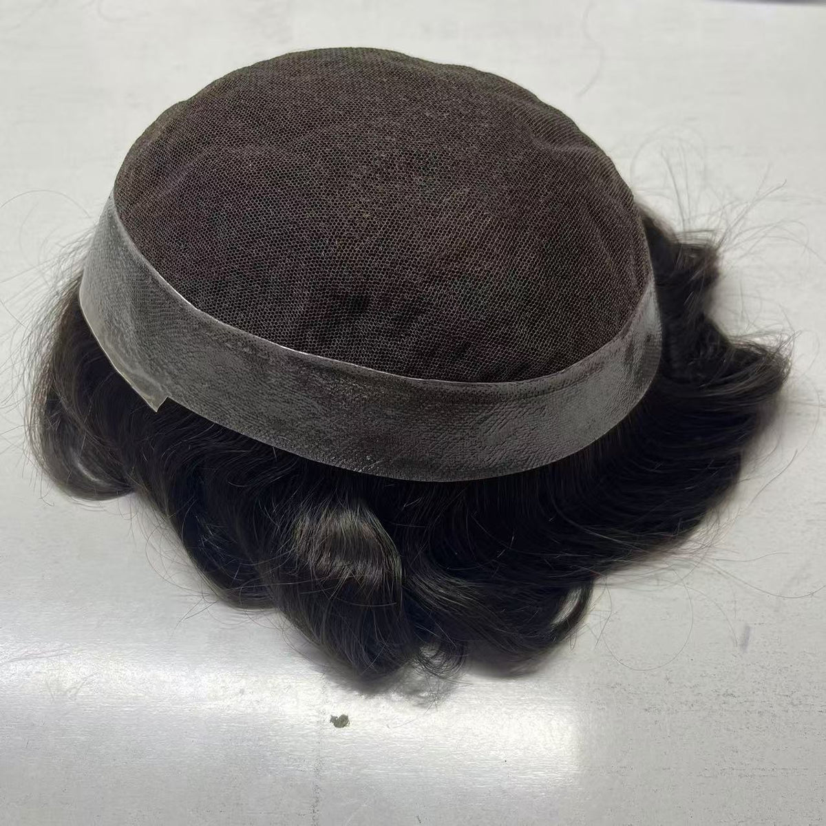 Back view of Australia system showing poly mesh crown and French lace front band with wavy hair