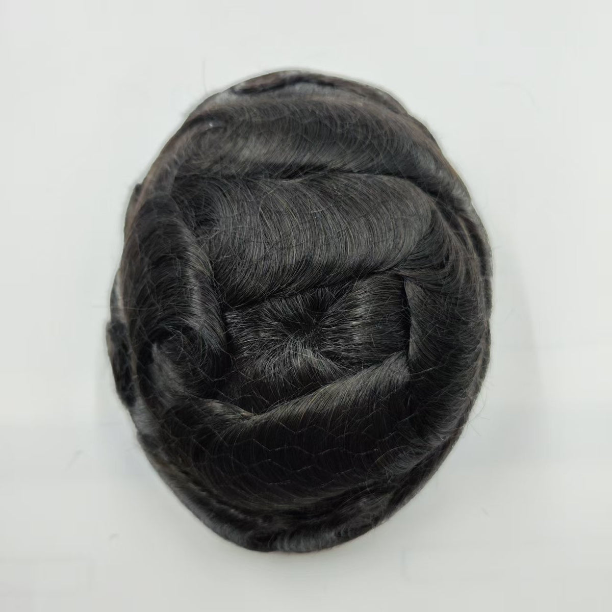 Top view of Hollywood hair system showing natural center part and full density in jet black