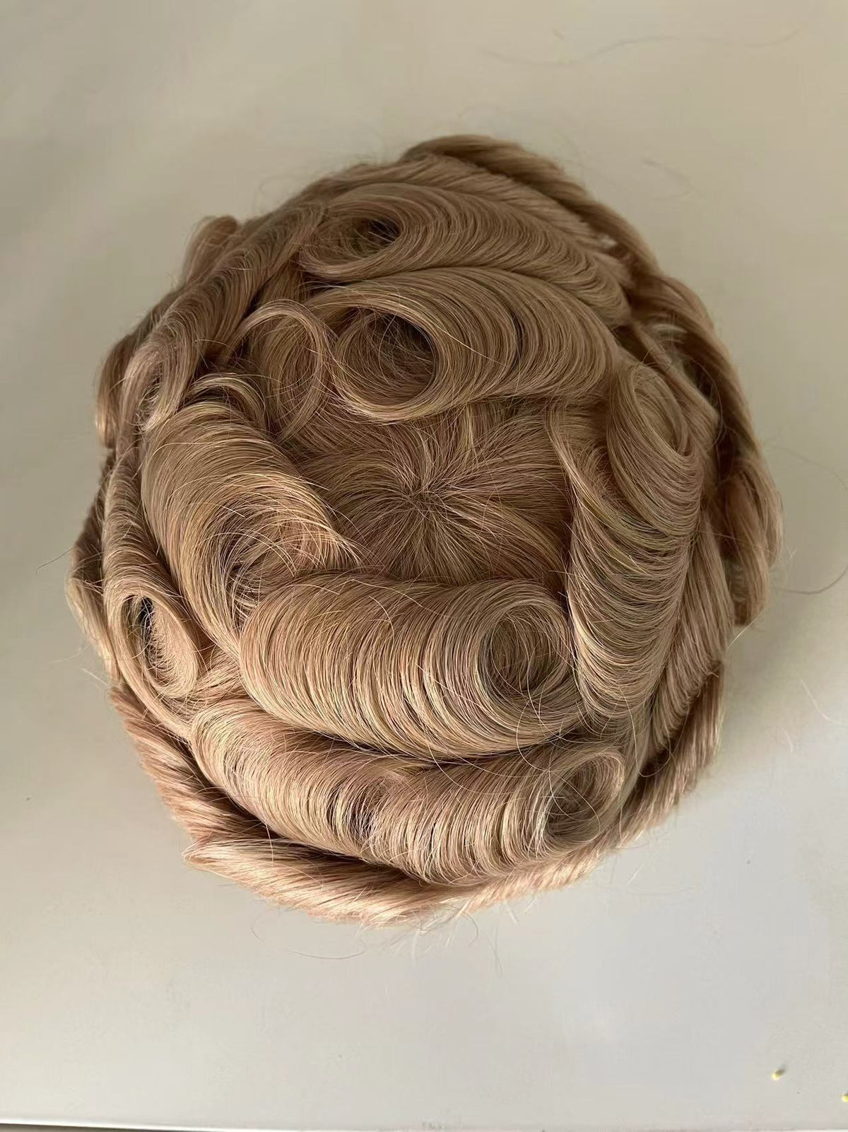 Top view of Full French lace system in golden-brown showing curly pattern and center part