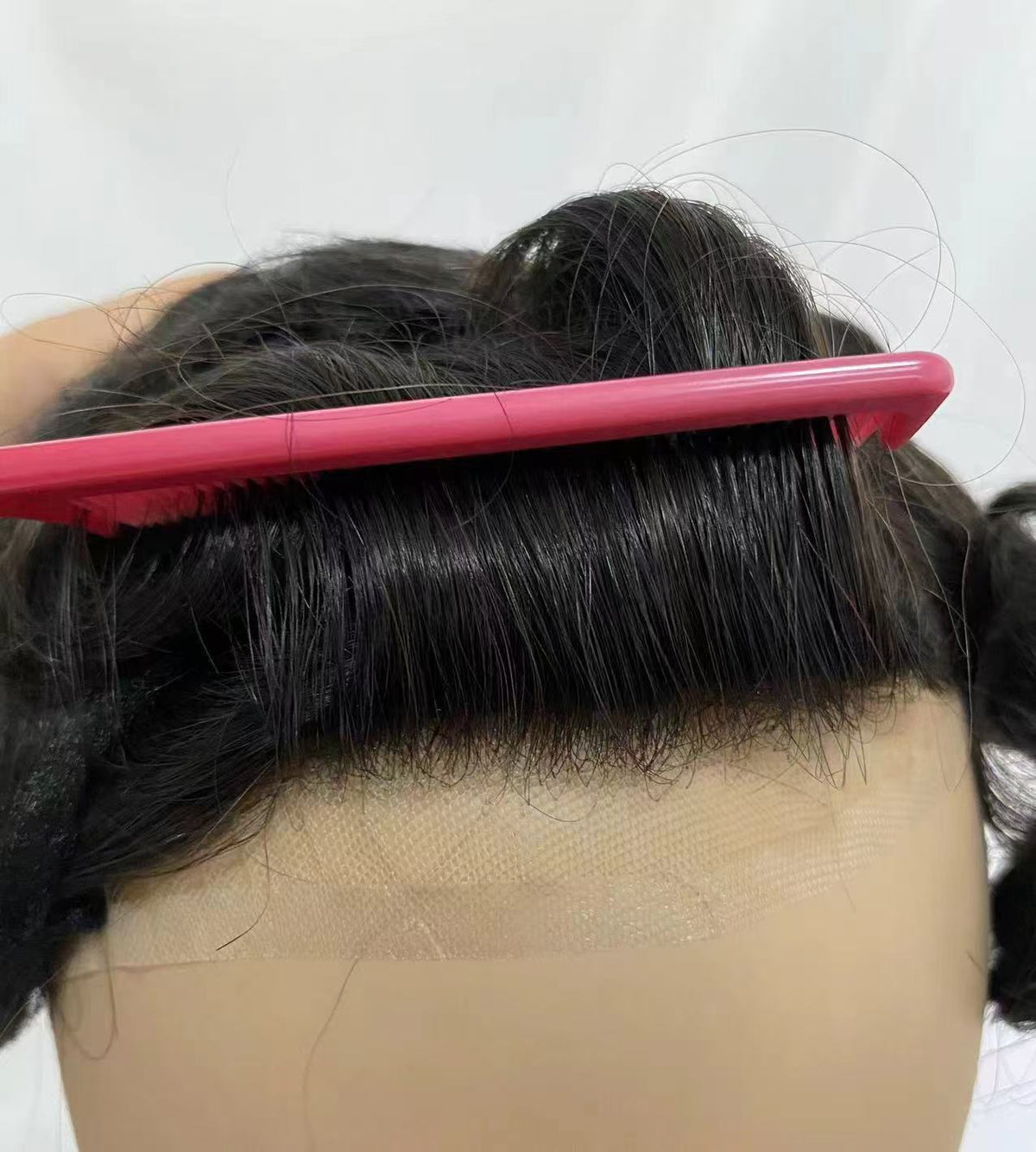 Front hairline on mannequin combed with pink comb showing baby hairs on transparent lace
